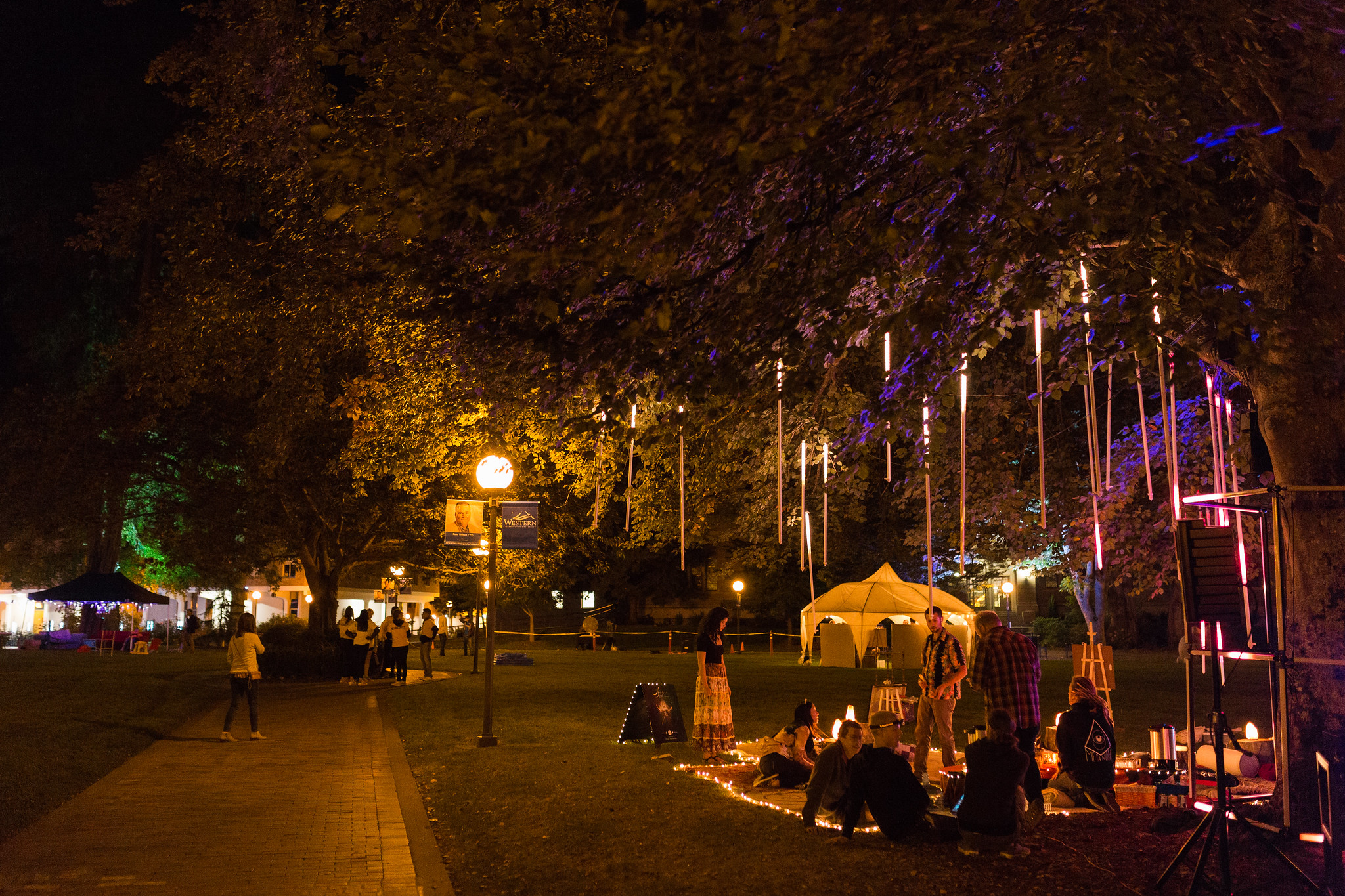 People gathered under lights in the Old Main lawn at night