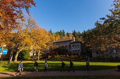 Lawn in front of old main, flanked by trees with fall foliage