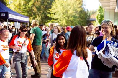 Students standing in Red Square during the AS Fall Info Fair wearing orange and white Residence Hall shirts. 