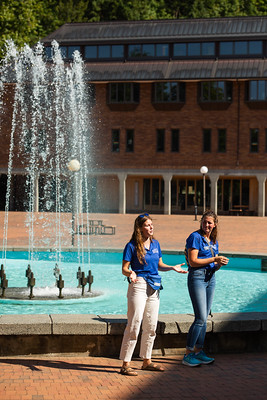 Two student tour guides in front of Fisher Fountain giving a campus tour